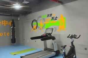 A gym with exercise equipment, including a treadmill and stationary bikes, and a punching bag. - Royal Phoenix Hotel Bac Ninh (Bac Ninh)