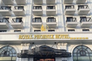 Het uiterlijk van het Royal Phoenix Hotel, met een opvallende ingang en balkons.