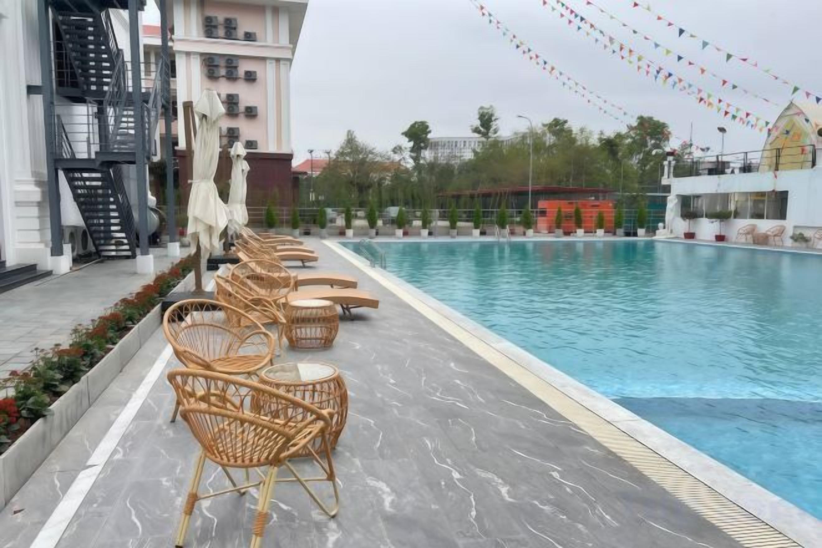 A swimming pool with lounge chairs and a building in the background.