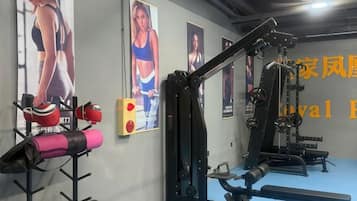 A gym with exercise equipment, posters on the wall, and a blue floor.