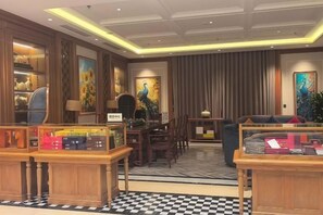 A hotel lobby with a checkered floor, wooden furniture, and artwork on the walls. - Royal Phoenix Hotel Bac Ninh (Bac Ninh)