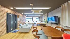 A modern hotel room with a wooden wall, a large bed, a sofa, a dining table, and a TV. - 4 min walk to Shinbashi Station, Ginza, Imperial Palace, Tokyo Tower / Max6 (Tokyo)