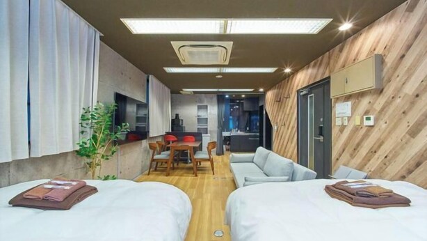 Une chambre d’hôtel avec deux lits, un coin repas et une kitchenette.
