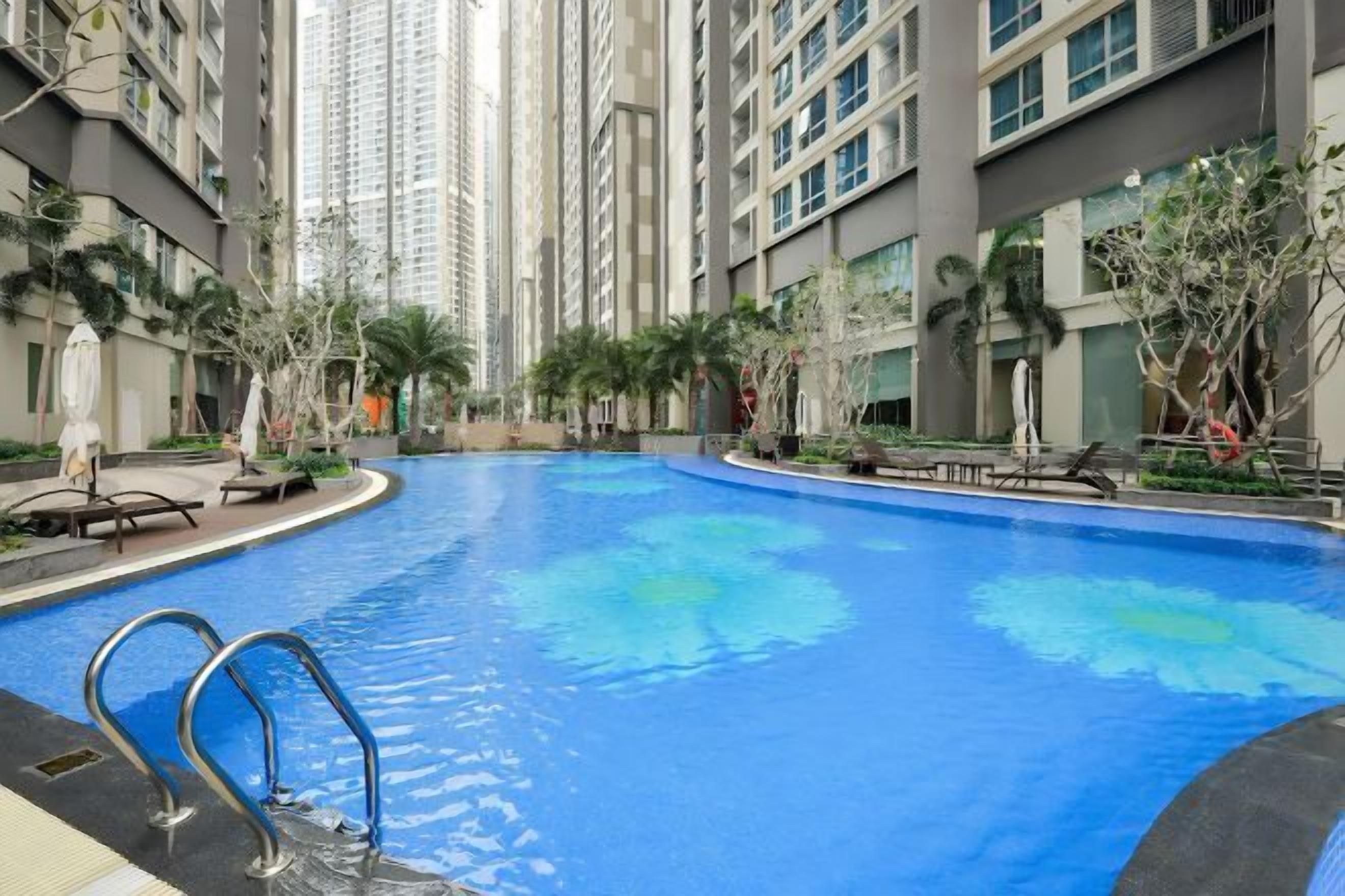 A swimming pool surrounded by high-rise residential buildings.