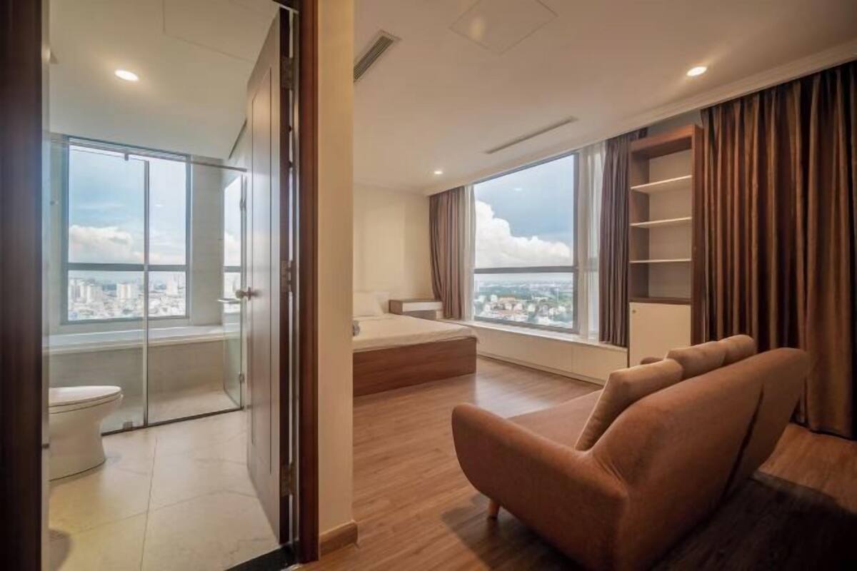 Een moderne woonkamer met een groot raam, een bank en uitzicht op de stad.
