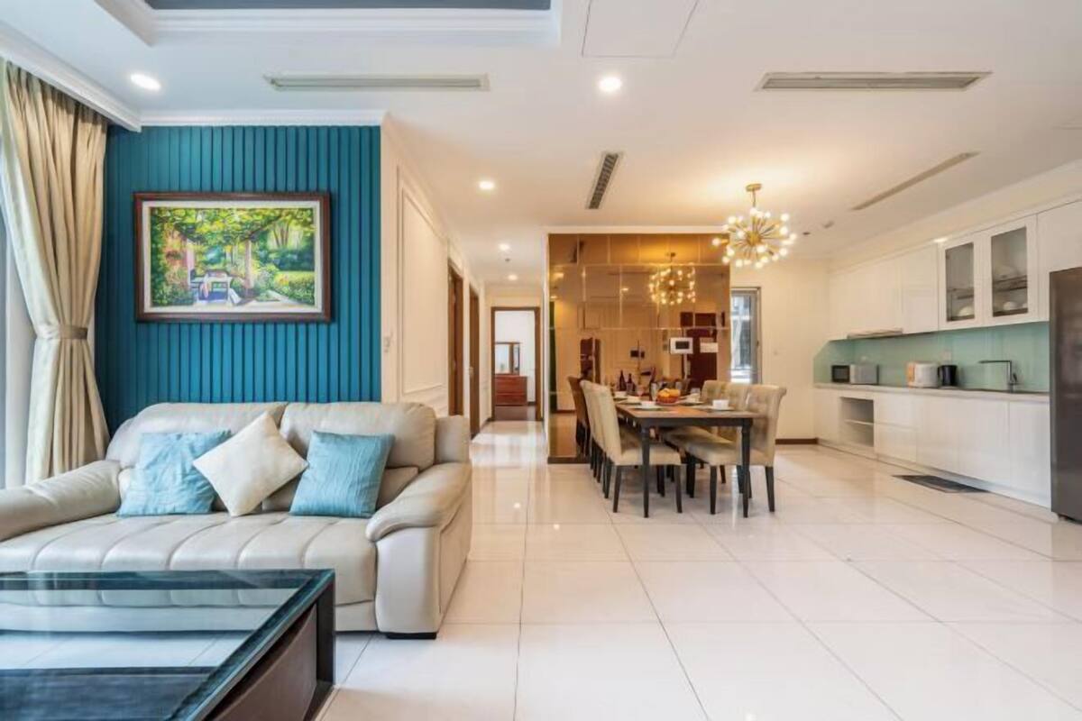 Een moderne woonkamer met een bank, eettafel en keukenhoek.