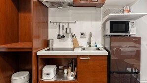 Eine kleine Küche mit Mikrowelle, Toaster und Holzschränken.