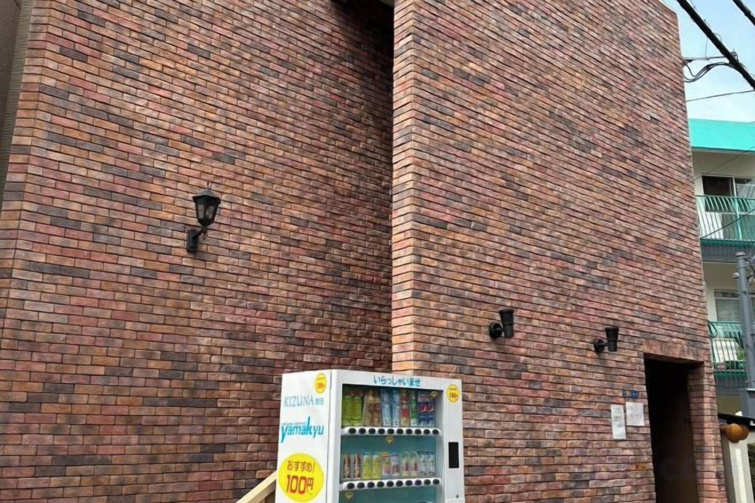 A brick building with a vending machine in front.