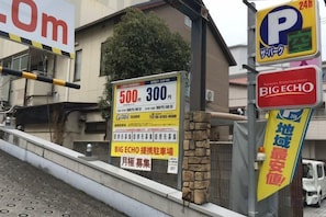 A parking sign with a 24-hour symbol, a Big Echo advertisement, and a stone wall. - STAYBB OSAKA Tamade｜Free WIFI｜8mins from Namba (Osaka)
