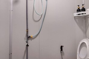 Un baño con inodoro, ducha y lavabo.
