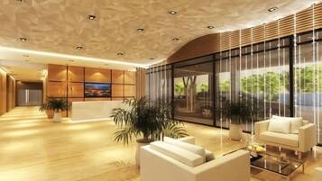 A modern lobby with a reception desk, seating area, large windows, and potted plants.