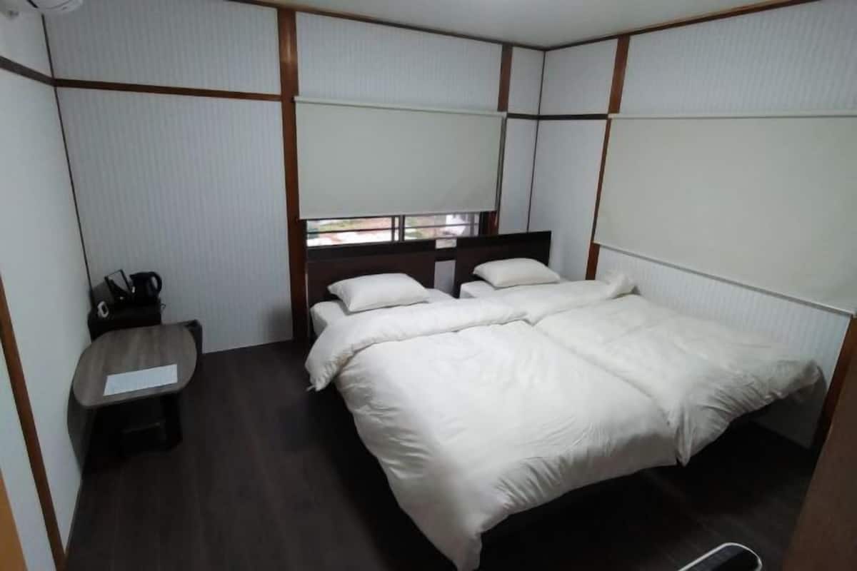 A room with a bed, a small table, and a window.