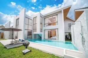A modern house with a swimming pool, a barbecue, and a patio area. - 4 Bedroom Modern Pool Villa Resort near Bangtao Beach Warm Plus (Phuket)