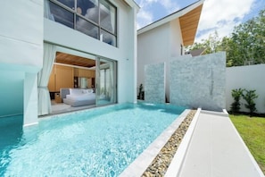 A modern house with a swimming pool, large windows, and a well-maintained lawn. - 4 Bedroom Modern Pool Villa Resort near Bangtao Beach Warm Plus (Phuket)