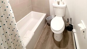 Un baño moderno con bañera, inodoro y cortina de ducha.