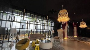 Ein modernes Wohnzimmer mit einer Couch, Sesseln, einem Couchtisch und dekorativen Lampen.