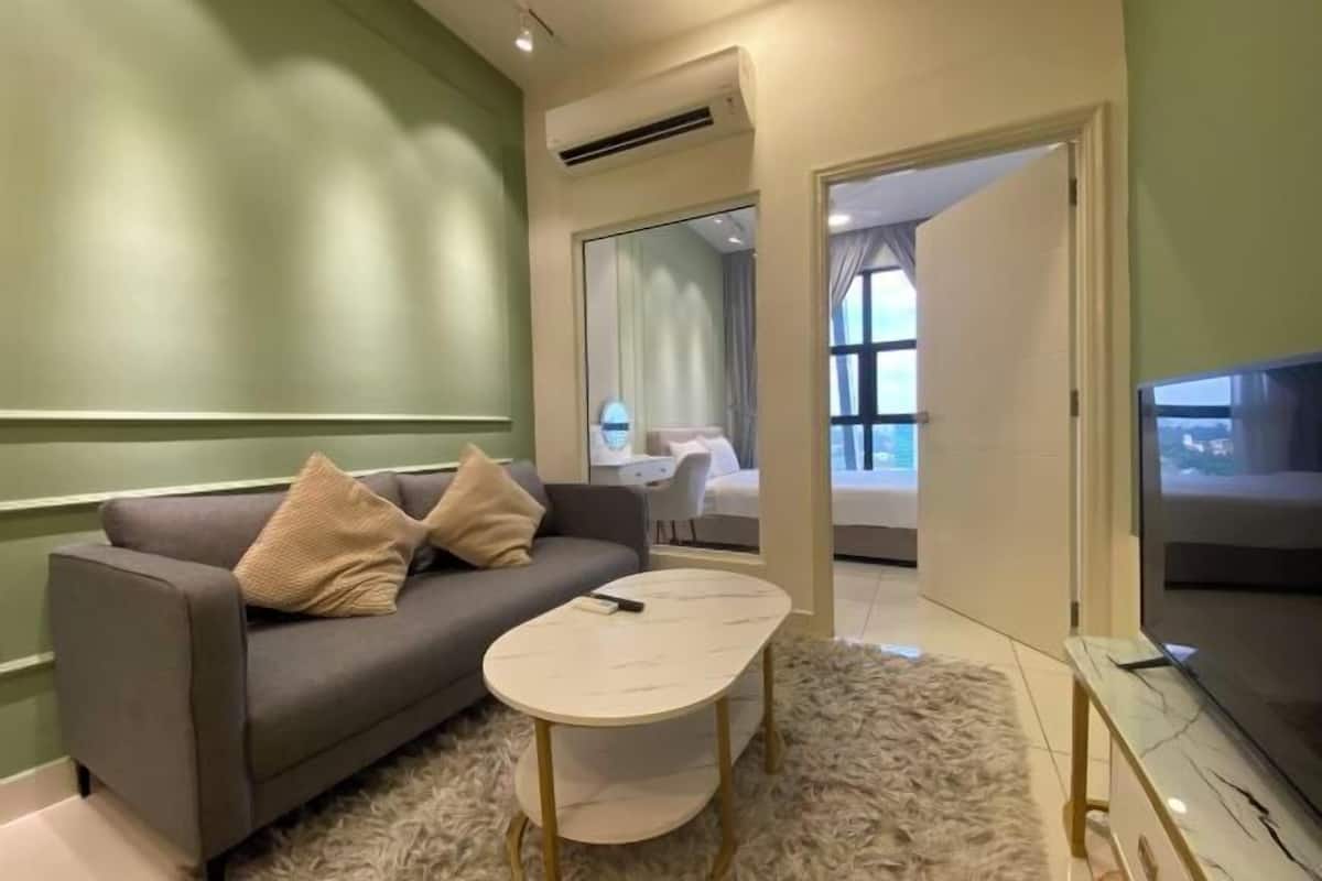 Un salon moderne avec un canapé, une table basse, un téléviseur et une vue sur une autre pièce.