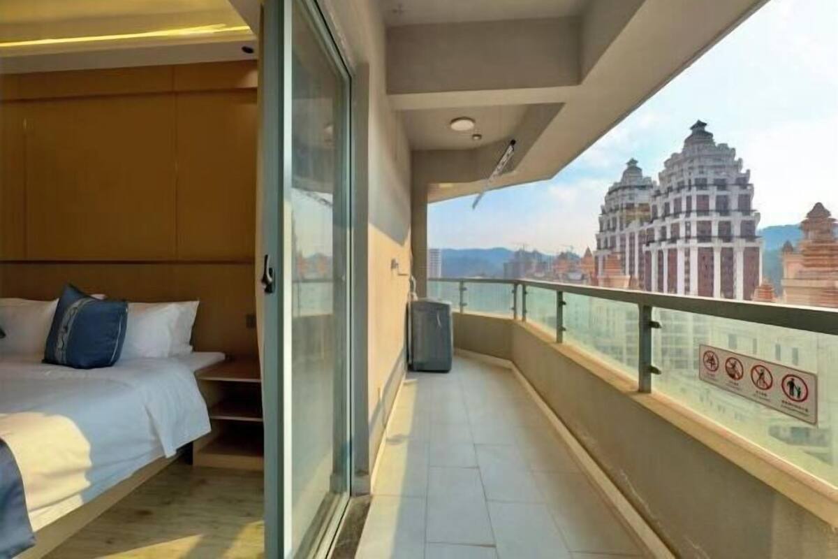 A balcony with a bed and a view of a temple.
