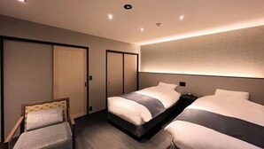 Une chambre d’hôtel avec un lit, une chaise et une armoire.
