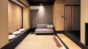 Une pièce avec un canapé, une petite table, un mur à motifs et un plancher en bois.