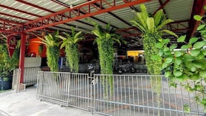 A covered parking area with metal railings and green plants growing vertically. - leader residences (Bang Phli)