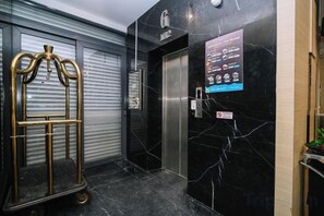 En hotellejlighed med en marmorvæg og et skilt, der viser faciliteter.