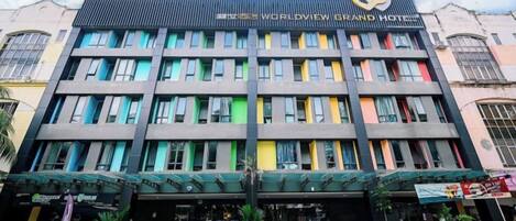 Un hotel de varios pisos con fachada moderna, múltiples balcones y señalización destacada que indica que es un hotel.