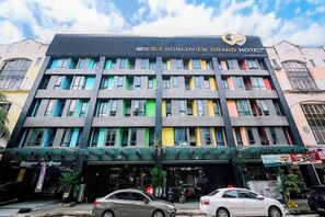 Een meerlaags hotel met een moderne gevel, meerdere balkons en duidelijke borden die aangeven dat het een hotel is.