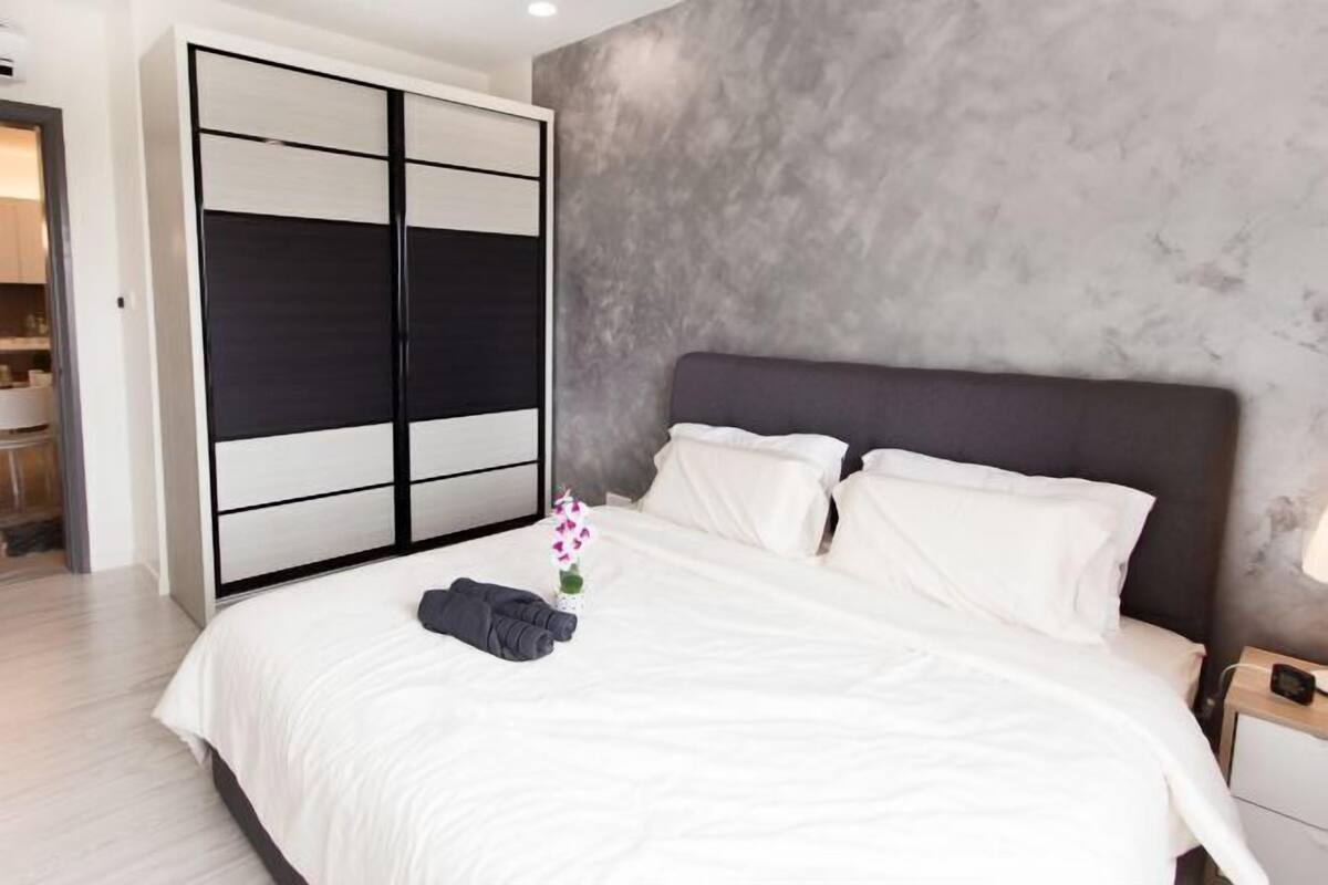 A bedroom with a bed, a wardrobe, and a nightstand.