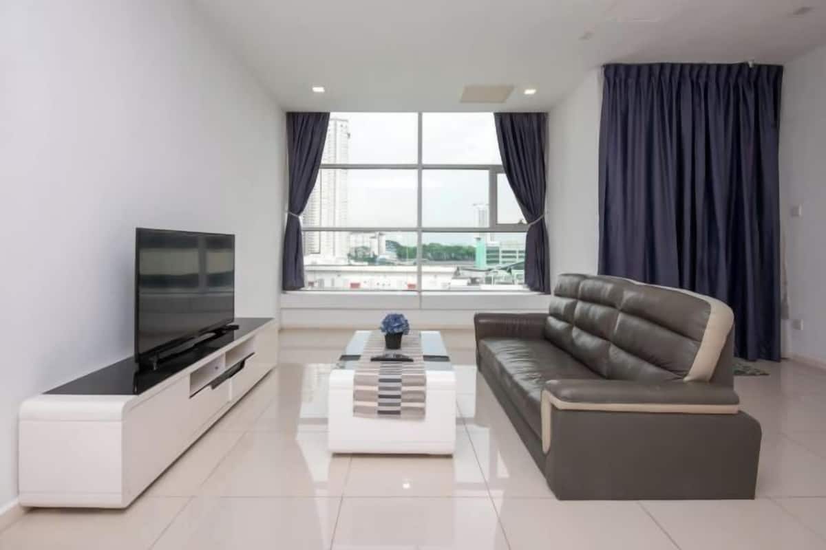 A modern living room with a flat-screen TV, a sofa, and a coffee table.