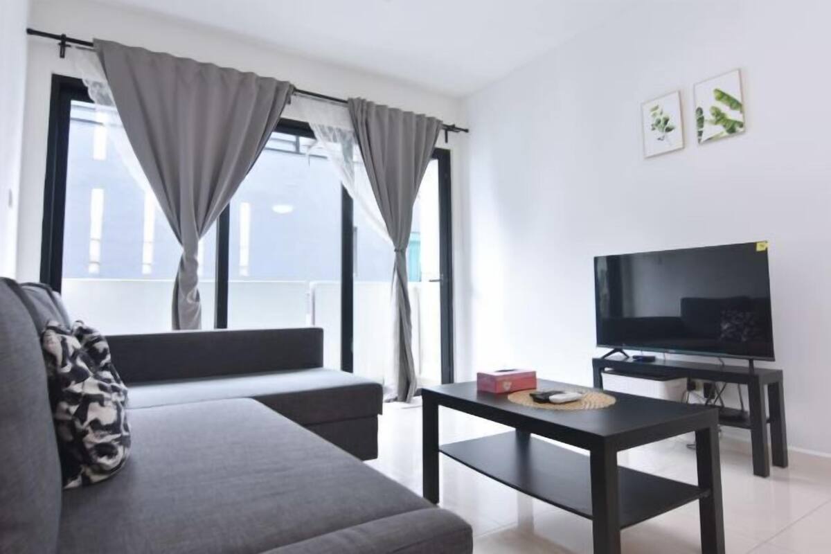 A modern living room with a sofa, a TV, and a table.