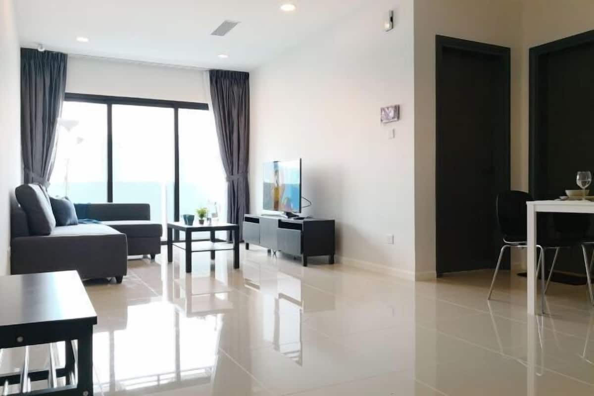 A modern living room with a sofa, a dining table, and a TV.