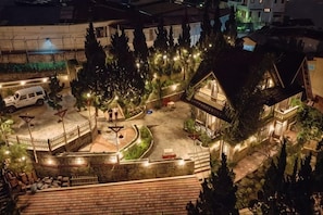A courtyard with a building, trees, and a white van.