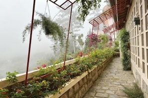 A stone pathway leading to a building with a garden.