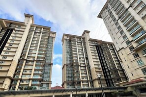 Un immeuble résidentiel de grande hauteur, doté de nombreux balcons, avec un ciel dégagé.