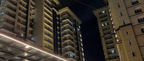 A high-rise building with multiple balconies and a glass facade.
