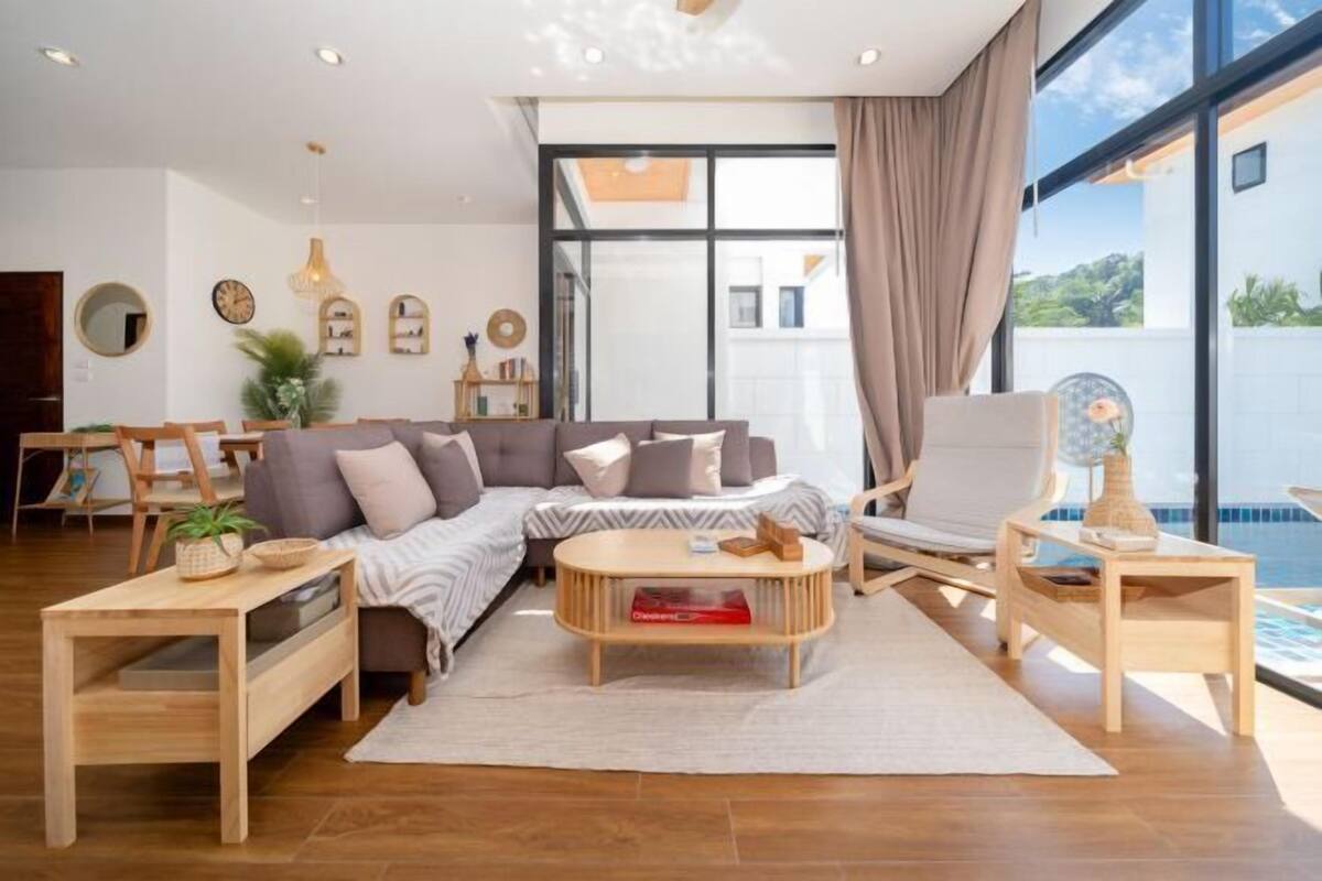 Een moderne woonkamer met een bank, salontafel en uitzicht op de omgeving.