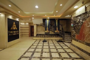 A hotel lobby with a checkered floor, a staircase, and a sign for 'The Muse Pyramid Inn'. - The Muse Pyramids INN (Kafr Nassar)