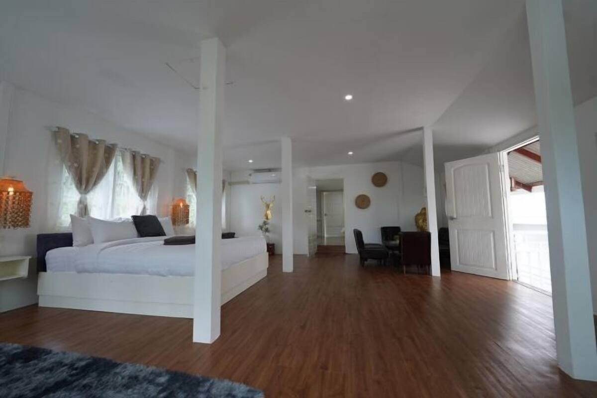 A bedroom with a bed, a desk, and a chair.
