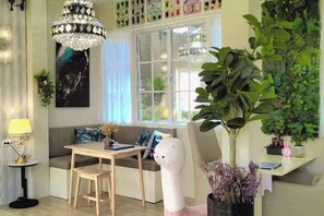 A cozy seating area with a bench, a table, and a decorative white sculpture. - Tropical Oasis Aoyon Beach House (Phuket)