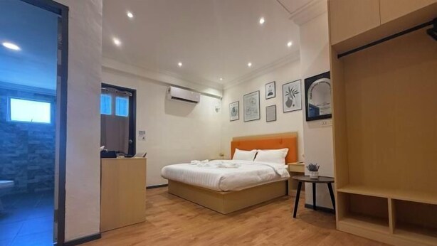 Un dormitorio con cama, mesita de noche y armario.