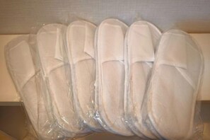 Ci sono file di ciabatte bianche in imballaggio di plastica.