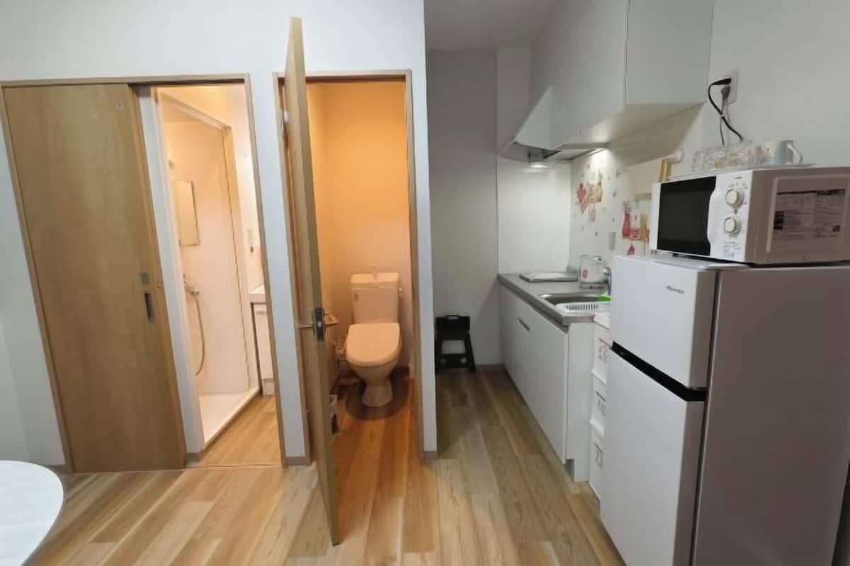 Eine kleine Küche mit Mikrowelle, Kühlschrank und Spüle.
