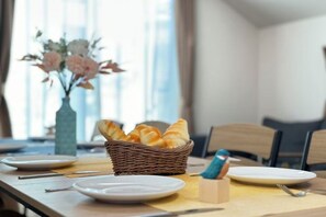 A dining table with plates, a basket of bread, and a vase of flowers. - nestay villa tokyo itabashi (Tokyo)