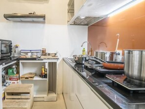 A kitchen with a microwave, stove, and various cooking utensils. - The Hotel Nicecy (Ho Chi Minh City)