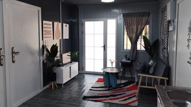 En moderne stue med sofa, sofabord og spiseplads med stol og bord.