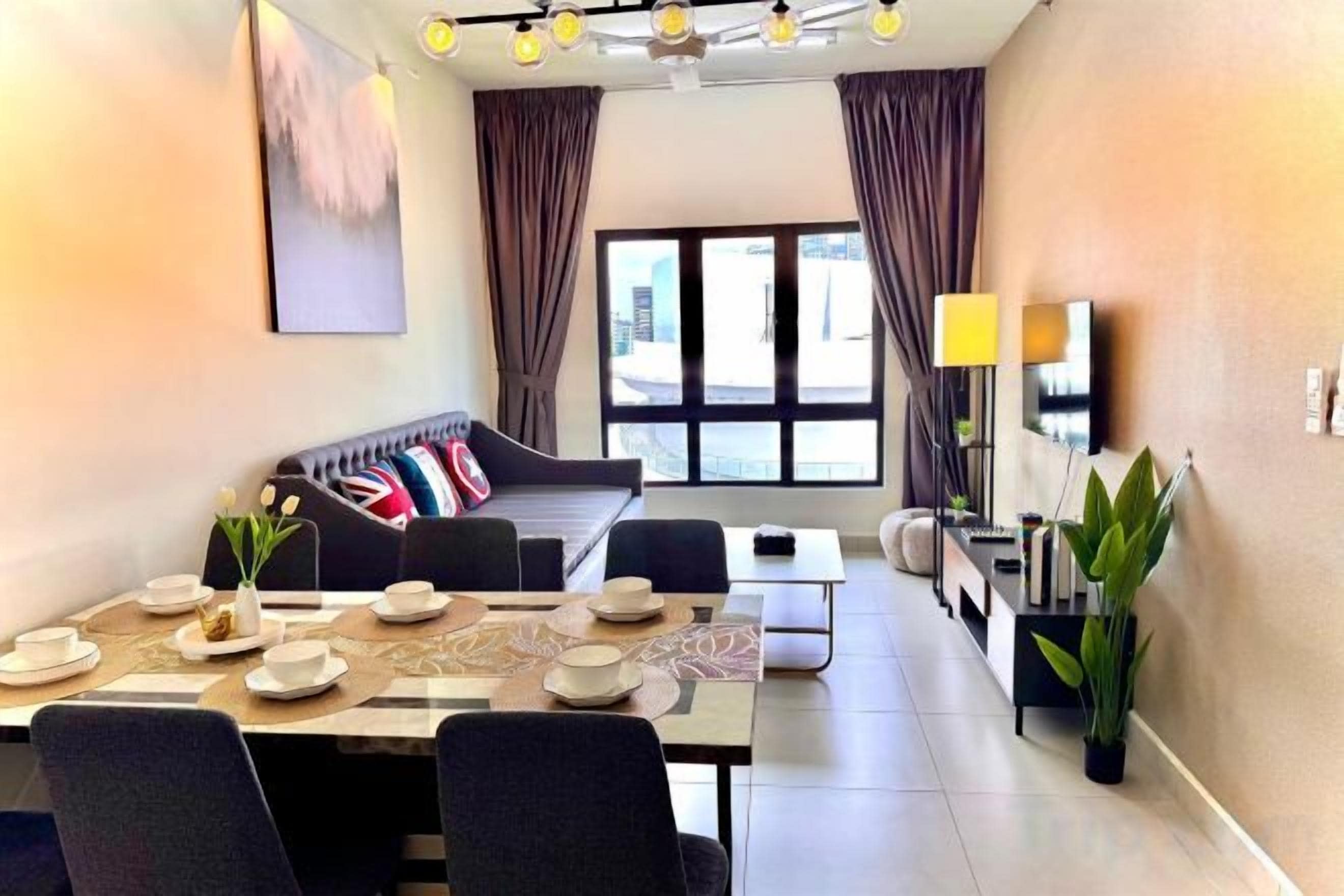 A modern living room with a sofa, dining table set for four, and a TV on a stand.