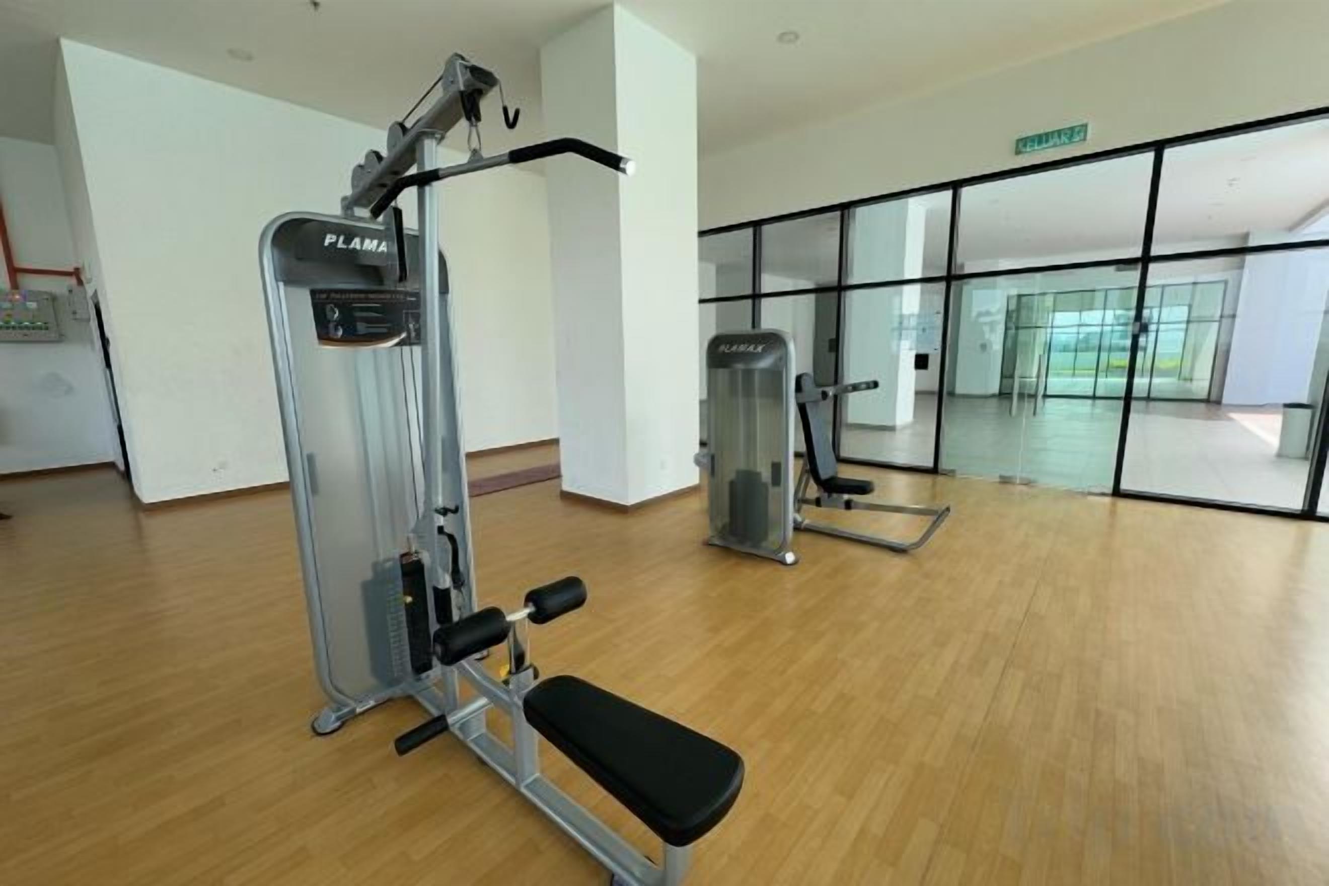 Un gimnasio con equipo de ejercicio, una banca y un ventanal grande.