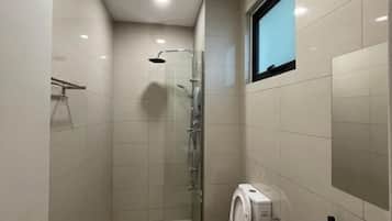 A modern bathroom with a shower, toilet, and a window.