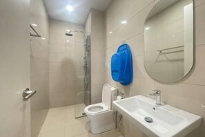 Ein modernes Badezimmer mit Duschkabine aus Glas, Toilette und Waschbecken mit Spiegel.